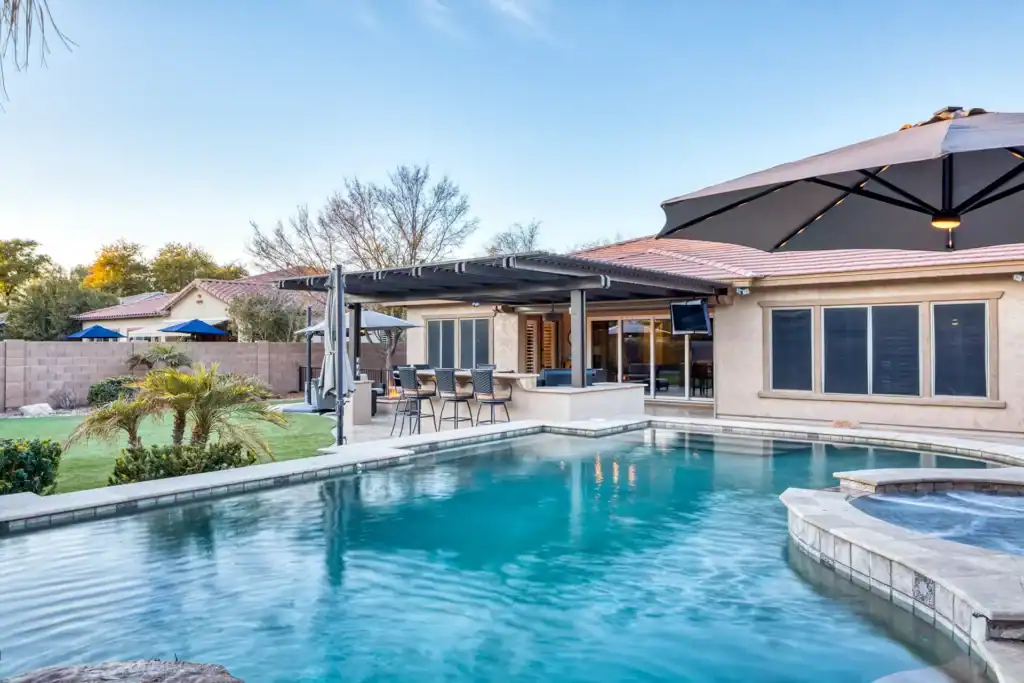 Custom backyard pool, spa, outdoor kitchen, and pergola in Chandler, Arizona, by a top pool builder.