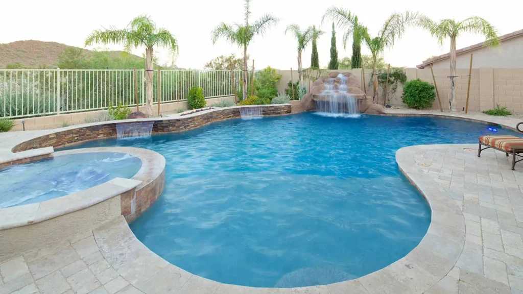 A sumptuous, tranquil pool and spa featuring a majestic waterfall and elegant patio, creating an exquisite outdoor sanctuary