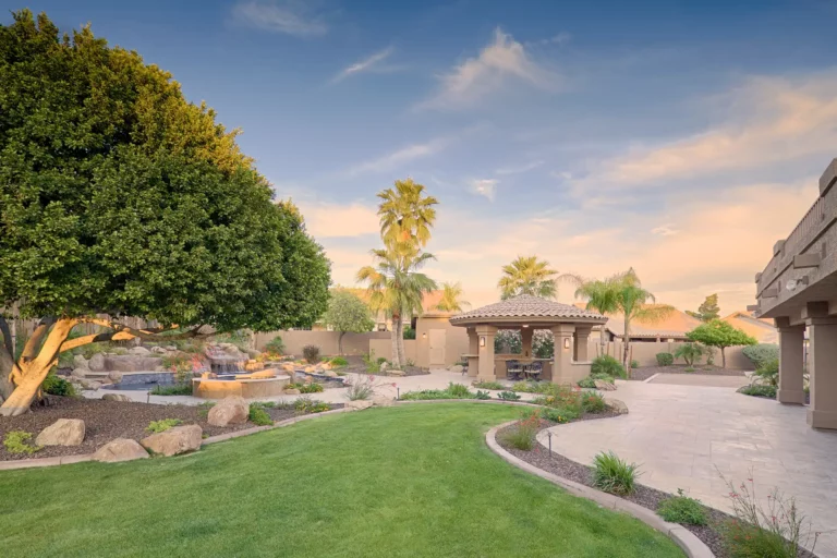 An exquisite Arizona backyard oasis featuring a serene waterfall pool, vibrant landscaping, and elegant gazebo