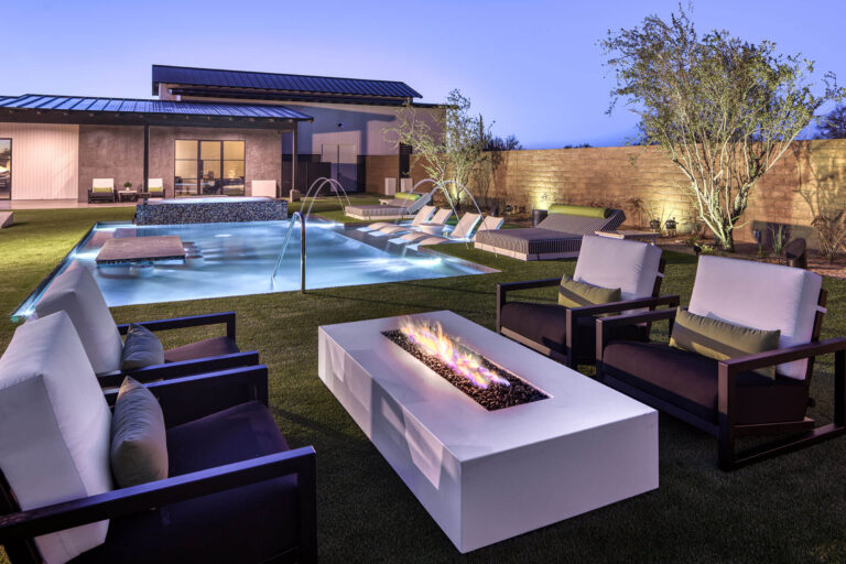 Exquisite twilight backyard oasis, serene pool with water features, luxurious seating area, and ambient fire pit glow