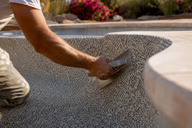 Hand applying plaster to pool surface